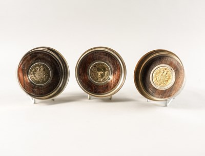 Lot 365 - A SET OF THREE SILVER MOUNTED CIRCULAR BOTTLE CASTERS (3)