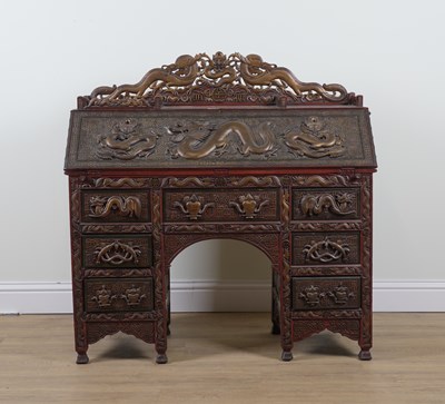 Lot 888 - A CHINESE EXPORT CARVED HARDWOOD RED LACQUER PARCEL GILT DECORATED SEVEN DRAWER WRITING DESK