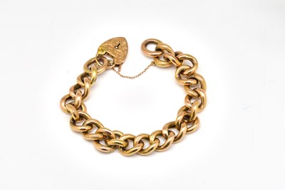 Lot 1893 - A GOLD CURB LINK BRACELET WITH A HEART SHAPED PADLOCK CLASP